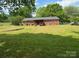 Well-manicured lawn leads to the red brick home's covered patio at 140 Porter Rd, Statesville, NC 28625
