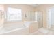 Inviting bathroom features a soaking tub, a glass-enclosed shower, and soft natural lighting at 14104 Kendrick Cross Rd, Charlotte, NC 28273