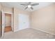 A carpeted bedroom with a ceiling fan, closet, and neutral paint, creating a calm atmosphere at 14104 Kendrick Cross Rd, Charlotte, NC 28273
