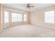 A spacious bedroom featuring neutral tones, a ceiling fan, and a bright bay window at 14104 Kendrick Cross Rd, Charlotte, NC 28273