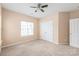 Cozy bedroom with neutral walls, carpet, and bright natural light, complemented by a ceiling fan and closet at 14104 Kendrick Cross Rd, Charlotte, NC 28273