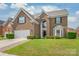 Charming brick home with well-manicured lawn, two-car garage, and inviting front entrance at 14104 Kendrick Cross Rd, Charlotte, NC 28273