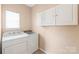 Laundry room with tiled floor, large window and side by side washer and dryer at 14104 Kendrick Cross Rd, Charlotte, NC 28273