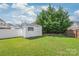Backyard shed on a green lawn surrounded by white and wooden fences at 14104 Kendrick Cross Rd, Charlotte, NC 28273