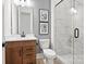 Contemporary bathroom features a wood vanity, toilet, and a glass-enclosed shower with marble-look tile at 14210 Kershaw Cir # 20, Huntersville, NC 28078
