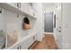 Well-organized mudroom with white cabinetry, hooks, bench, and hardwood floors, offering stylish storage at 14210 Kershaw Cir # 20, Huntersville, NC 28078