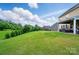 Spacious backyard with green grass, landscaping, and a covered patio area for entertaining at 14316 Baytown Ct, Charlotte, NC 28078