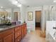 Bathroom with tiled floors, wood cabinets, granite countertops, and a glass-enclosed shower at 14316 Baytown Ct, Charlotte, NC 28078