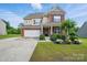 Charming two-story home with brick and beige siding, a manicured lawn, and inviting curb appeal at 14316 Baytown Ct, Charlotte, NC 28078