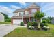 Charming two-story home with brick and beige siding, a manicured lawn, and inviting curb appeal at 14316 Baytown Ct, Charlotte, NC 28078