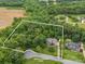 Aerial view of the property showcasing a wooded lot, residence, and surrounding landscape with approximate property lines at 144 Chickasaw Dr, Shelby, NC 28152