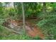 Picturesque creek flowing through the property, with lush greenery, creating a serene environment at 144 Chickasaw Dr, Shelby, NC 28152