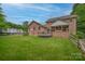 Rear exterior view of a brick home featuring a large backyard, deck, covered patio and RV parking at 144 Chickasaw Dr, Shelby, NC 28152