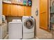 Well-organized laundry room features modern washer and dryer set, storage cabinets, and laminate flooring at 144 Chickasaw Dr, Shelby, NC 28152
