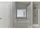 A neutral-toned bathroom features a soaking tub next to the glass enclosed shower at 14501 Asheton Creek Dr, Charlotte, NC 28273