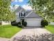 Charming two-story home with a well-manicured lawn and attached two-car garage, framed by mature trees at 14501 Asheton Creek Dr, Charlotte, NC 28273