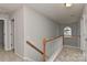 Hallway featuring a wooden banister and natural light from the arched window at the end at 14501 Asheton Creek Dr, Charlotte, NC 28273