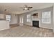 Spacious living room featuring plush carpeting, a fireplace, and abundant natural light at 14501 Asheton Creek Dr, Charlotte, NC 28273