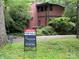 Charming home surrounded by lush greenery with a 'For Sale' sign out front at 1451 Blueberry Ln, Charlotte, NC 28226
