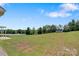 Expansive backyard showing the lawn, outbuilding, surrounding trees, and a clear blue sky at 154 Stable Brook Ln, Taylorsville, NC 28681