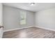 Bedroom featuring neutral walls, wood-look flooring, white trim, and a window with natural light at 154 Stable Brook Ln, Taylorsville, NC 28681