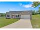Charming single-story home with well-manicured lawn and a long driveway leading to an attached garage at 154 Stable Brook Ln, Taylorsville, NC 28681