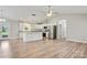 Bright kitchen with white cabinets, stainless steel appliances, granite countertops, and wood-look flooring at 154 Stable Brook Ln, Taylorsville, NC 28681