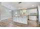 Bright kitchen with white cabinets, stainless steel appliances, granite countertops, and wood-look flooring at 154 Stable Brook Ln, Taylorsville, NC 28681