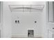 Laundry room showcasing white walls with utility hookups, storage shelf, and a neutral trim at 154 Stable Brook Ln, Taylorsville, NC 28681