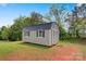 Outbuilding in backyard with neutral siding, white trim, a metal roof, and a grassy lawn at 154 Stable Brook Ln, Taylorsville, NC 28681