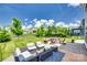 Inviting backyard patio featuring cozy seating, a fire pit, and a beautifully landscaped lawn for outdoor enjoyment at 16008 Weeping Valley Dr, Fort Mill, SC 29715
