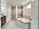 Bright bathroom showcasing a shower and a large soaking tub with tile surround at 16008 Weeping Valley Dr, Fort Mill, SC 29715