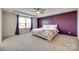 Spacious bedroom with a ceiling fan, a large window, and a accent purple wall at 16008 Weeping Valley Dr, Fort Mill, SC 29715