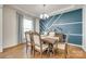 Bright dining room features a geometric accent wall, hardwood floors and elegant chandelier at 16008 Weeping Valley Dr, Fort Mill, SC 29715