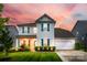 Charming two-story home showcasing blue shutters, a well-manicured lawn, and a convenient two-car garage at 16008 Weeping Valley Dr, Fort Mill, SC 29715