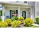 Charming front porch with a seating area, surrounded by lush landscaping and a well-kept lawn at 16008 Weeping Valley Dr, Fort Mill, SC 29715