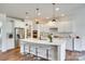 Modern kitchen featuring white cabinetry, stainless steel appliances, a large island, and elegant pendant lighting at 16008 Weeping Valley Dr, Fort Mill, SC 29715