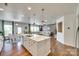 Open-concept kitchen with island seating, seamlessly connecting to the dining and living areas with hardwood floors at 16008 Weeping Valley Dr, Fort Mill, SC 29715