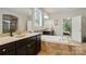 Bright bathroom featuring double vanity, soaking tub, and doorway leading to the bedroom at 161 Leaning Tower Dr, Mooresville, NC 28117