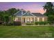 Charming brick home with a cozy front porch, colorful flowers, and lush green lawn at 161 Leaning Tower Dr, Mooresville, NC 28117