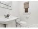 Classic bathroom with a vintage-style sink, toilet, and window for natural light at 1809 Jameston Dr, Charlotte, NC 28209