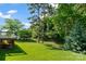 Grassy backyard with mature trees and landscaping, plus a wooden back deck at 2016 Townview Dr, Kannapolis, NC 28081
