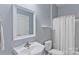 Well-lit bathroom with white fixtures, blue paint, and vanity mirror at 2016 Townview Dr, Kannapolis, NC 28081