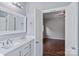 Bathroom with double vanity and doorway view into bedroom with gleaming hardwood floors at 2016 Townview Dr, Kannapolis, NC 28081