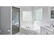 Bright bathroom featuring a soaking tub, glass shower, and marble tile accents at 2016 Townview Dr, Kannapolis, NC 28081