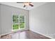 Bedroom featuring hardwood floors, neutral paint, a ceiling fan, and a large window at 2016 Townview Dr, Kannapolis, NC 28081