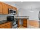Eat-in kitchen featuring wooden cabinetry, a stainless steel microwave, oven, and a breakfast bar at 2016 Townview Dr, Kannapolis, NC 28081