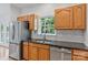 Well-lit kitchen featuring stainless steel appliances, wood cabinets, and granite countertops at 2016 Townview Dr, Kannapolis, NC 28081