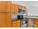 Kitchen featuring stainless steel oven and microwave, as well as wooden cabinetry and tiled backsplash at 2016 Townview Dr, Kannapolis, NC 28081