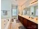 Bathroom with double vanity, large mirror, and a soaking tub at 3678 Privette Rd # 349, Matthews, NC 28104